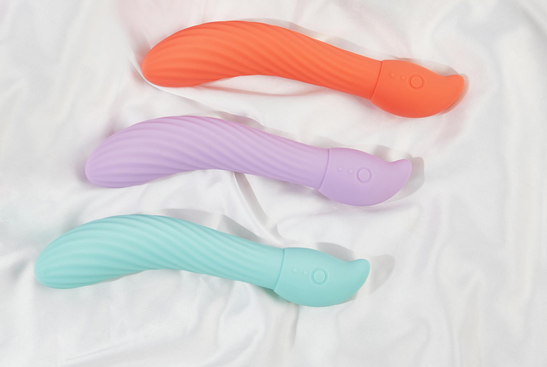 Silicone sex toys arranged on white fabric, highlighting smooth texture
