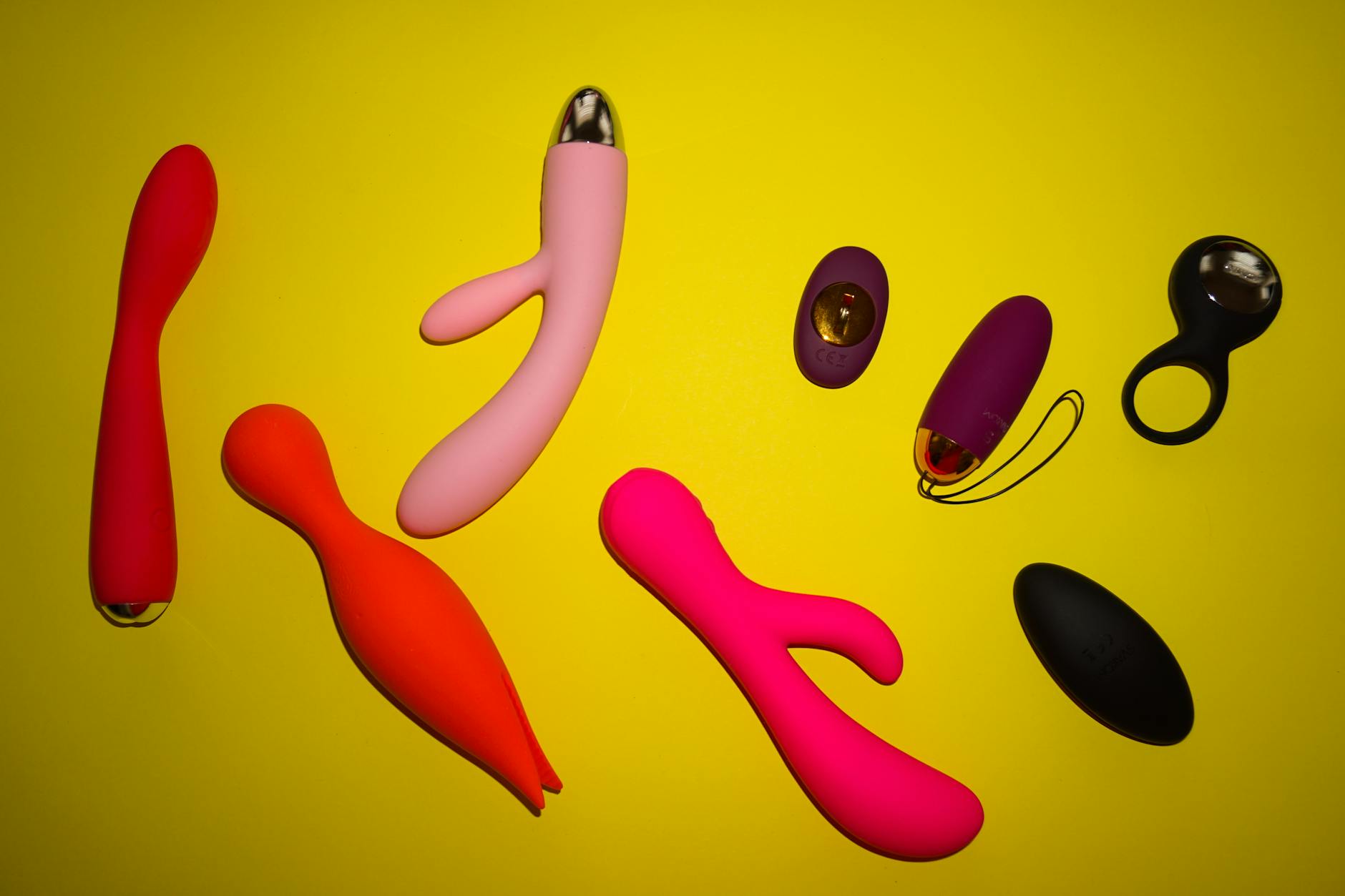 Vibrant collection of colorful clitoral vibrators and toys arranged on a bright surface
